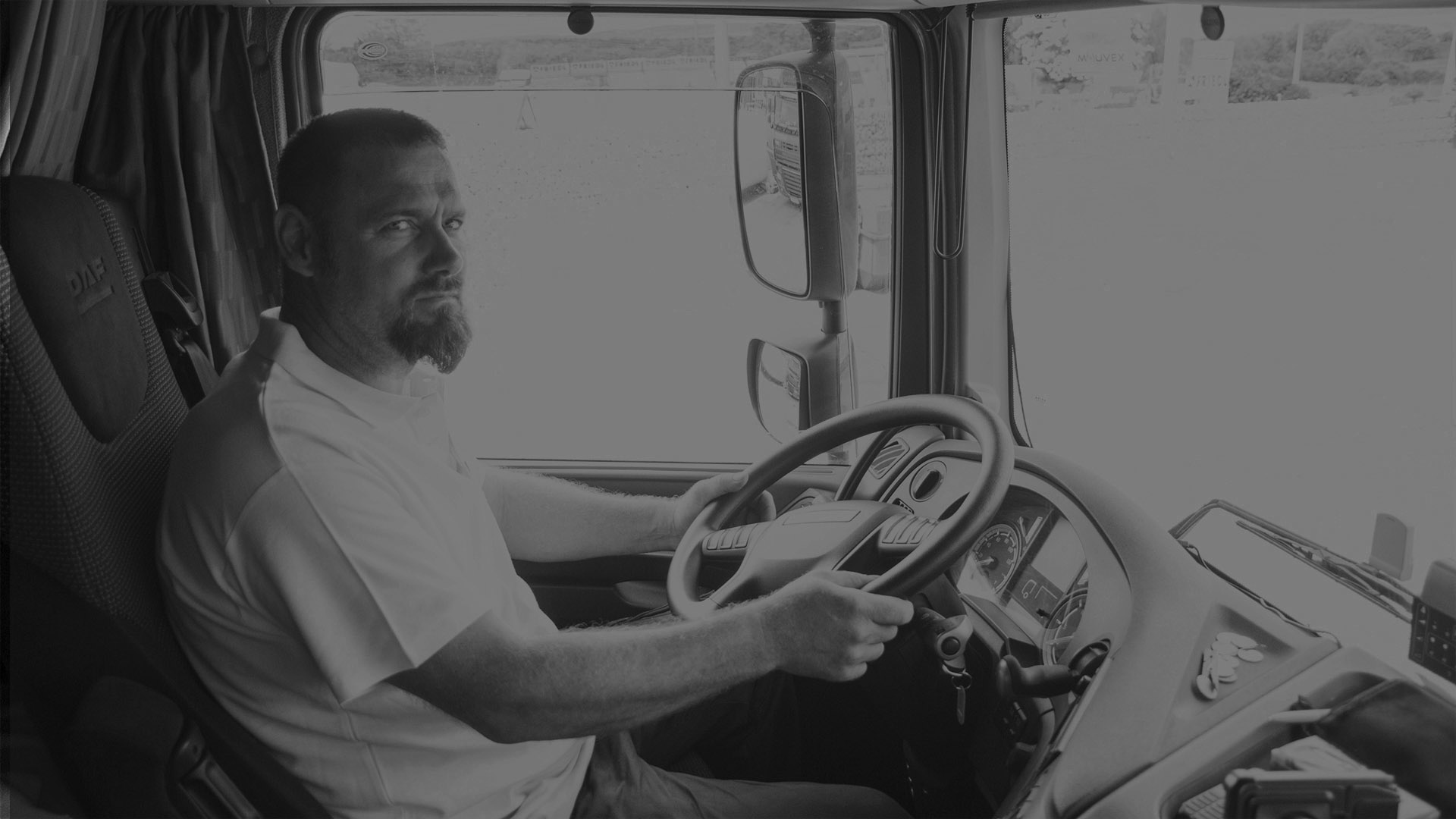 nemzetközi kamionsofőr állás. Nemzetközi kamionsofőr vezeti a kamiont. Kék DAF kamion fülke